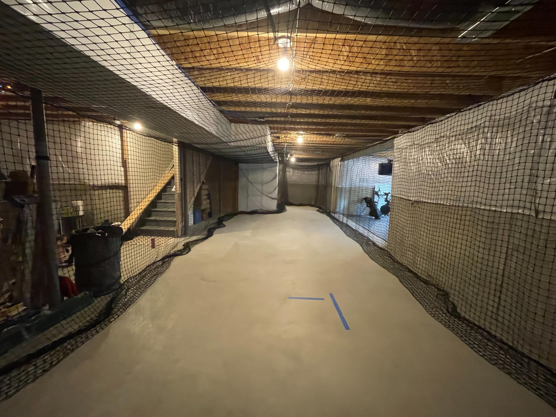 Custom Indoor Batting Cage Installation – Macomb County, MI Concrete slab poured for custom basement batting cage with netted ceiling and reinforced walls – indoor sports training area built in Macomb County, Michigan