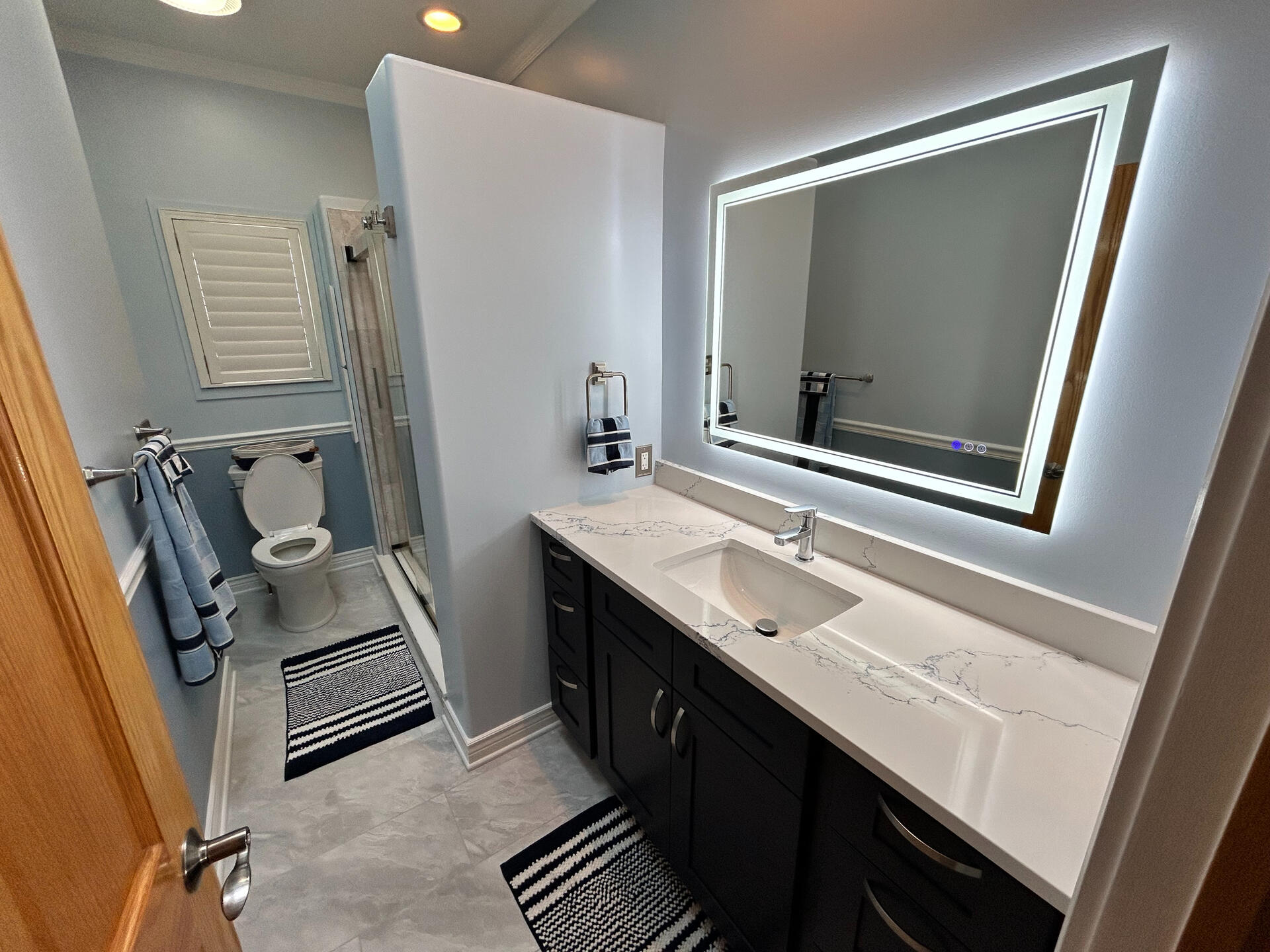 Double Vanity Bathroom Remodel with LED Mirror – Rochester, MI Updated bathroom with dual-sink vanity, backlit LED mirror, and minimalist design – full renovation in Rochester, Michigan