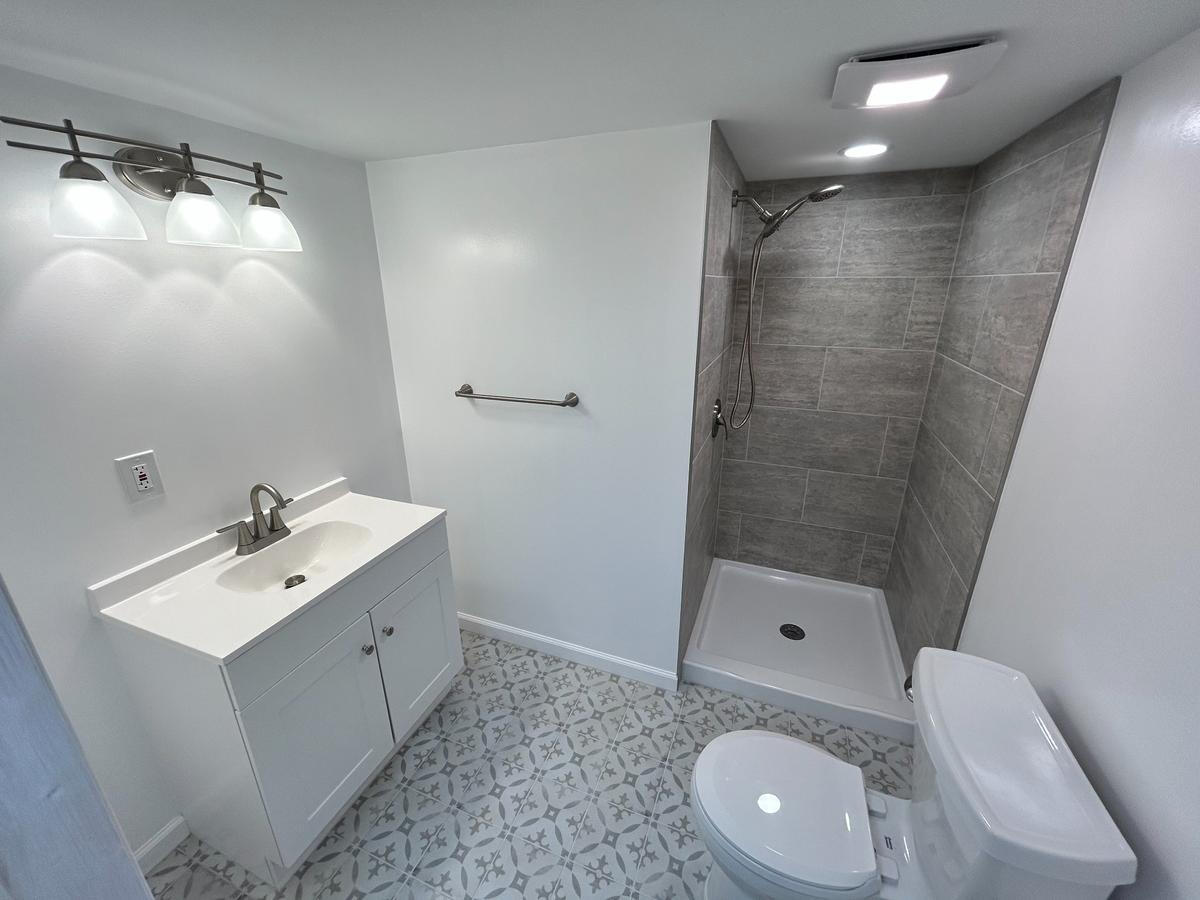 Walk-In Shower with Rainfall Showerhead – Ferndale, MI Custom walk-in shower with rainfall showerhead, stone tile walls, and frameless glass enclosure – modern remodel in Ferndale, Michigan