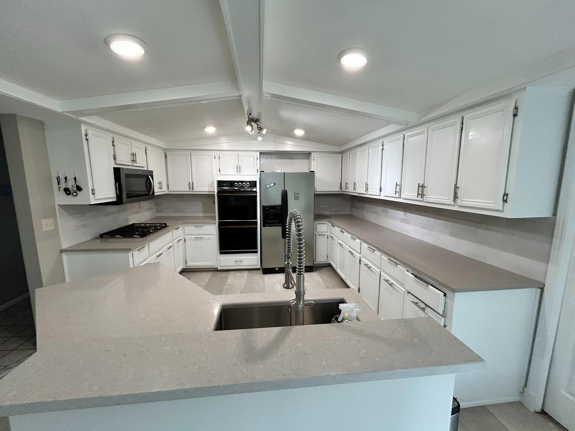 Spacious White Kitchen Remodel with Open Layout – MI Large white kitchen remodel with wraparound counters and recessed lighting – full renovation project Rochester Hills, Michigan